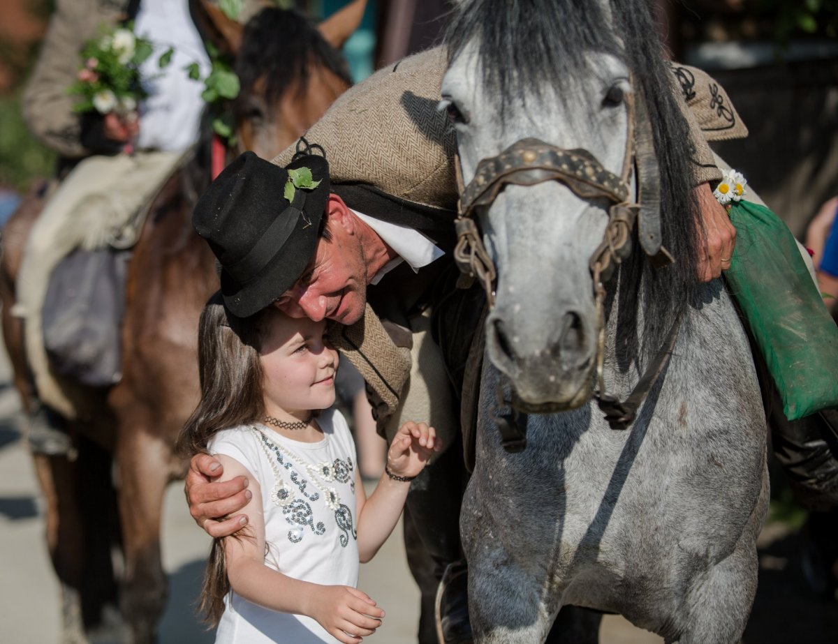 Az otthonmaradt nők és gyerekek büszkeséggel fogadják a hazatérő lovas zarándokokat •  Fotó: Erdély Bálint Előd