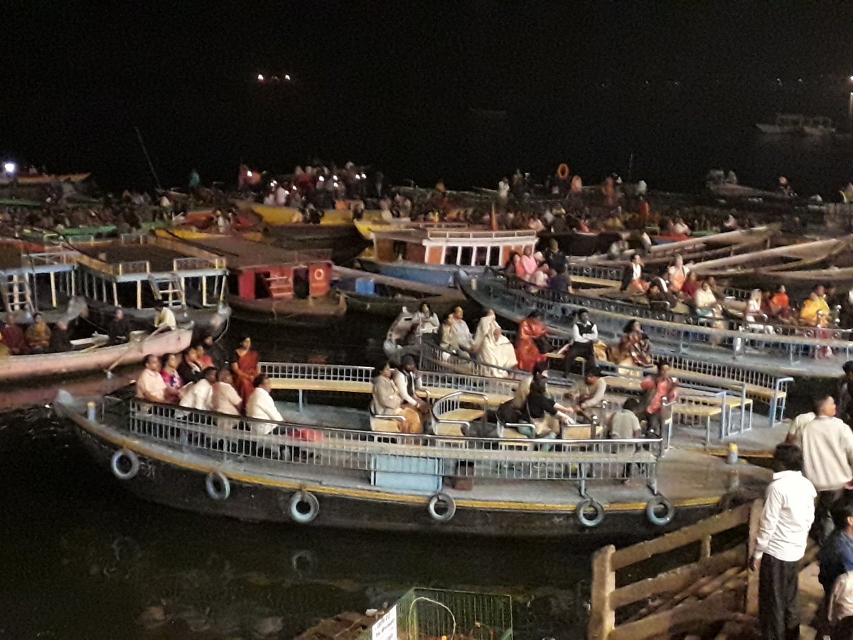 Sokan csónakokban ülve követik figyelemmel az esti szertartást Váránasziban, a Gangeszen •  Fotó: Kiss Judit