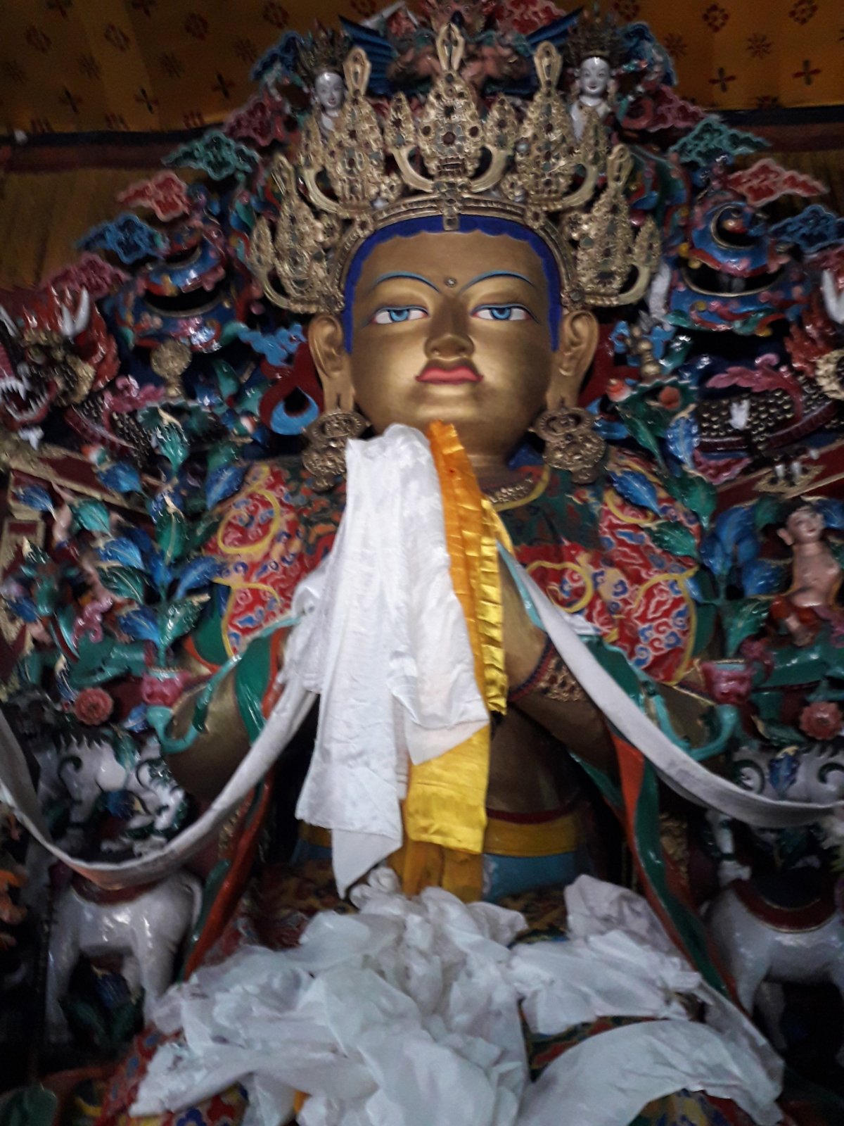 A dardzsilingi Ghoom buddhista kolostor belseje. Buddha szobrát számos fehér és sárga üdvözlő sál (katak) lepi el, melyet tiszteletük jeleként hoznak követői •  Fotó: Kiss Judit