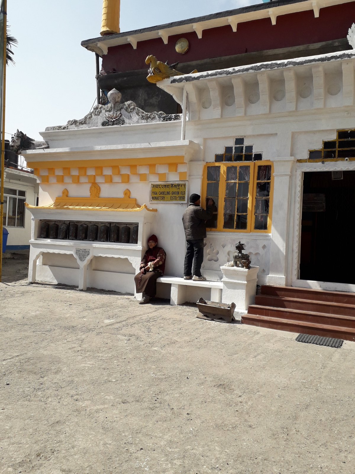 A dardzsilingi Ghoom buddhista kolostor falán is imamalmok sorakoznak (balról). A helyiek elmagyarázták, óramutató járásával megegyező irányban kell megforgatni a hengereket. •  Fotó: Kiss Judit
